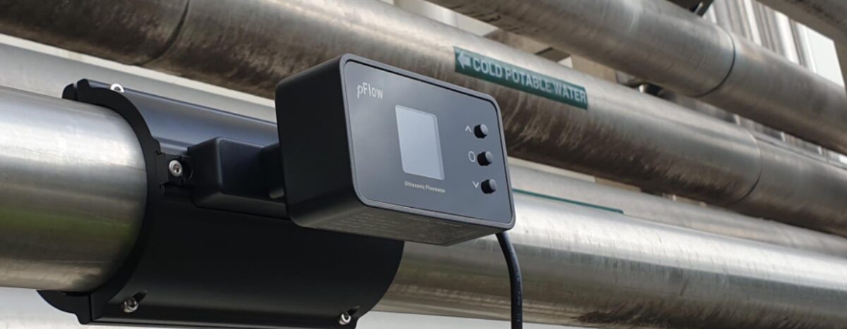 Flow meter on pipes labeled hot, cold, and chilled water. This flow meter measures how flow meters work in industrial plumbing systems.