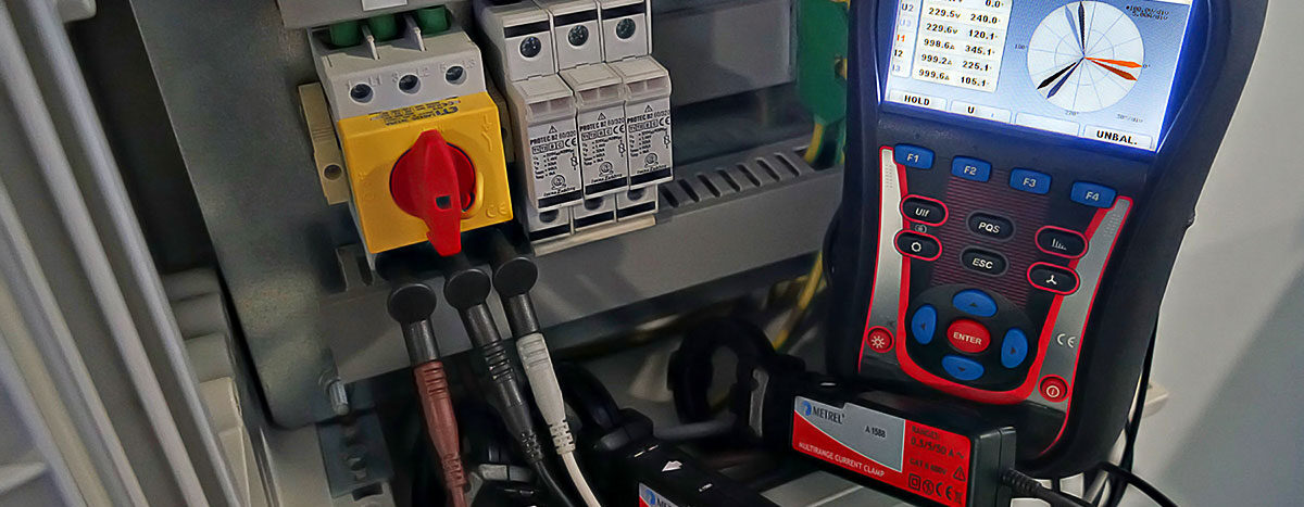 Metrel PQA measuring PV inverter efficiency. Electrical panel with Metrel MI 2892 power quality analyzer showing a phase diagram on its screen.
