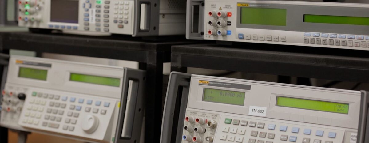 Calibration Services: Close-up of test equipment used for calibration. Features various electronic measuring instruments with digital displays and control panels.